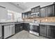 A functional kitchen showcasing dark cabinetry, modern stainless steel appliances, and tile backsplash at 14521 W Gelding Dr, Surprise, AZ 85379
