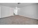 Spacious living area featuring plush carpeting, white walls, and access to the upper level of the home at 14521 W Gelding Dr, Surprise, AZ 85379