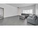 Open living room with gray sectional, tile floors, and a bright, airy feel at 14521 W Gelding Dr, Surprise, AZ 85379