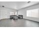 Bright living room features tile flooring, and a comfortable gray sectional sofa at 14521 W Gelding Dr, Surprise, AZ 85379