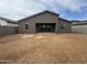 Back exterior view showcasing a home with a dirt backyard and small patio at 15777 W Cheryl Dr, Waddell, AZ 85355