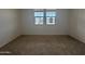 Cozy bedroom with plush carpeting and natural light streaming through the window at 15777 W Cheryl Dr, Waddell, AZ 85355