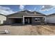 New home with a three-car garage, brick driveway, and modern desert landscaping at 15777 W Cheryl Dr, Waddell, AZ 85355