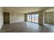 This living room features drywall, natural light from the sliding glass door and wood-look tile flooring at 15777 W Cheryl Dr, Waddell, AZ 85355