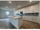 Modern kitchen featuring an island and ample storage space with white cabinets at 15777 W Cheryl Dr, Waddell, AZ 85355