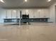 Modern kitchen with white cabinets, stylish backsplash and a quartz countertop at 15777 W Cheryl Dr, Waddell, AZ 85355