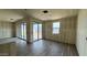 Open living space with multiple sliding glass doors, windows, and wood look ceramic floors at 15777 W Cheryl Dr, Waddell, AZ 85355