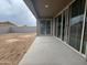 Covered patio with sliding glass doors overlooks a dirt backyard enclosed by a block fence at 15777 W Cheryl Dr, Waddell, AZ 85355
