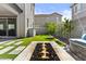 Backyard featuring artificial turf, a stone fire pit, landscaping, and views of the neighborhood at 15837 N 74Th Ln, Peoria, AZ 85382