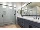 Bright bathroom with dual vanity, black fixtures, and a large glass-enclosed shower at 16064 W Montana De Oro Dr, Surprise, AZ 85387