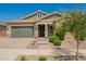 Charming single-story home featuring a paved walkway, desert landscaping, and an attached two-car garage at 16064 W Montana De Oro Dr, Surprise, AZ 85387