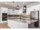 Bright kitchen with white cabinetry, stainless steel appliances, and a spacious island with a sink at 16064 W Montana De Oro Dr, Surprise, AZ 85387