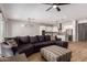 Open-concept living room featuring a large sectional sofa, stylish ottoman, and modern ceiling fan at 16064 W Montana De Oro Dr, Surprise, AZ 85387