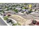 An aerial view of a community park with playground, walking path and residential homes, plus an indicator pin on one house at 16438 W Buchanan St, Goodyear, AZ 85338