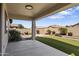 Covered back patio with synthetic grass surrounded by desert landscaping and privacy walls at 16438 W Buchanan St, Goodyear, AZ 85338