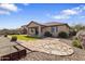 Well maintained backyard with patio, synthetic grass, stone landscaping and planters at 16438 W Buchanan St, Goodyear, AZ 85338
