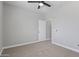 Spacious carpeted bedroom featuring a ceiling fan and a door at 16438 W Buchanan St, Goodyear, AZ 85338