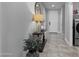 Inviting hallway with tile flooring, a decorative console table, and access to laundry and other rooms at 16438 W Buchanan St, Goodyear, AZ 85338