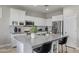 Modern kitchen with white cabinets, stainless steel appliances, subway tile backsplash, and a large center island at 16438 W Buchanan St, Goodyear, AZ 85338