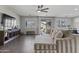Open-concept living area with wood floors, stylish sectional, and entertainment center at 16438 W Buchanan St, Goodyear, AZ 85338