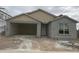 Exterior of a house during construction showing unfinished facade, garage, and window details at 17153 W Sweet Iron Pass, Surprise, AZ 85387