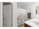 Well-lit bathroom featuring double sinks, floral shower curtain, and modern fixtures at 1920 E Bell Rd # 1034, Phoenix, AZ 85022