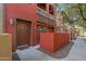 Inviting front entrance of a red-painted stucco condo with a brown door, white trim, and small balcony at 1920 E Bell Rd # 1034, Phoenix, AZ 85022