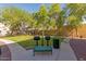 Community grilling area featuring two barbecue grills, a bench and trash receptacle surrounded by trees and green space at 1920 E Bell Rd # 1034, Phoenix, AZ 85022