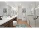 Bright bathroom featuring a double vanity with modern fixtures and a glass-enclosed shower with a built-in bench at 20373 W Rovey Ave, Buckeye, AZ 85396
