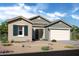 Charming single-story home featuring desert landscaping, a two-car garage, and a stylish gray and beige color scheme at 20373 W Rovey Ave, Buckeye, AZ 85396