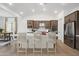 Open concept kitchen with a large island, bar seating, stainless steel appliances, and wooden cabinets at 20373 W Rovey Ave, Buckeye, AZ 85396