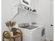 Bright laundry room featuring modern appliances and a decorative shelf above at 20373 W Rovey Ave, Buckeye, AZ 85396