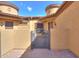 Private courtyard featuring a wrought iron gate, neutral stucco, and brick pavers under a bright blue sky at 2041 N 88Th St, Mesa, AZ 85207