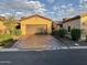 A single-Gathering home with a long brick driveway leading to a two-car garage with a neutral-colored exterior and terracotta roof at 2041 N 88Th St, Mesa, AZ 85207