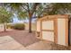 Backyard featuring desert landscaping, privacy wall, and a storage shed at 20449 N 105Th Ave, Peoria, AZ 85382