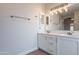 Bathroom features a double sink vanity, large mirror and modern light fixture at 20449 N 105Th Ave, Peoria, AZ 85382