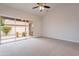 Spacious bedroom featuring a sliding glass door to the back yard, plush carpet and a ceiling fan at 20449 N 105Th Ave, Peoria, AZ 85382