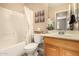 Bathroom features a wood vanity, full mirror, shower-tub combo and modern fixtures at 23006 W Cantilever St, Buckeye, AZ 85326