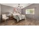 Bedroom with a ceiling fan, wooden floors, neutral decor, and a bright window at 23006 W Cantilever St, Buckeye, AZ 85326