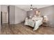 Bedroom with wood-look flooring, side tables, a neutral color palette, and plenty of space at 23006 W Cantilever St, Buckeye, AZ 85326