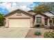 Home exterior featuring desert landscaping, a two-car garage, and neutral paint at 23006 W Cantilever St, Buckeye, AZ 85326