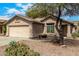 Home exterior featuring desert landscaping, a two-car garage, and neutral paint at 23006 W Cantilever St, Buckeye, AZ 85326