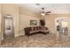Living room with tile flooring, a ceiling fan, and a brown couch at 23006 W Cantilever St, Buckeye, AZ 85326