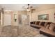 Living room with tile flooring, a ceiling fan, and a brown couch at 23006 W Cantilever St, Buckeye, AZ 85326