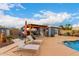 Backyard with a pool, outdoor kitchen, pergola, and lounge chairs at 23040 W Hammond Ln, Buckeye, AZ 85326