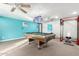 Basement with a pool table, gym equipment, and bright aqua-painted walls at 23040 W Hammond Ln, Buckeye, AZ 85326