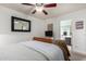 This bedroom features a ceiling fan, adjacent bathroom, and wicker-frame bed at 23040 W Hammond Ln, Buckeye, AZ 85326