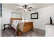 This bedroom has a wicker-frame bed, ceiling fan, and adjacent sitting area at 23040 W Hammond Ln, Buckeye, AZ 85326