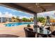Covered patio with outdoor seating overlooking the pool and backyard at 23040 W Hammond Ln, Buckeye, AZ 85326