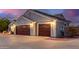 A spacious three-car garage featuring beautiful doors, exterior lighting, and a well-maintained driveway at 23040 W Hammond Ln, Buckeye, AZ 85326